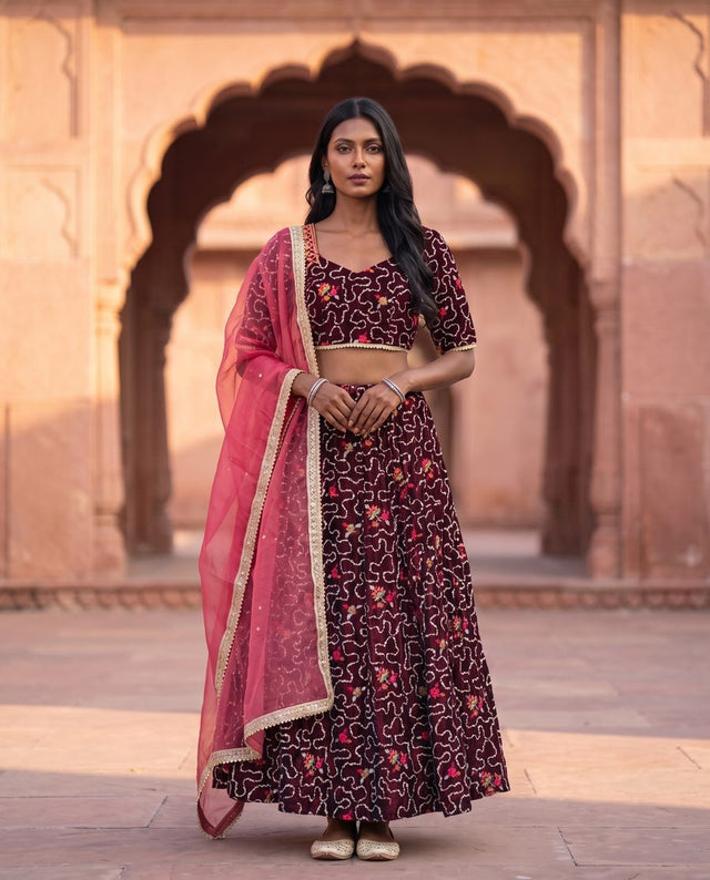Front view of maroon lehenga choli with sweetheart neckline and pink dupatta